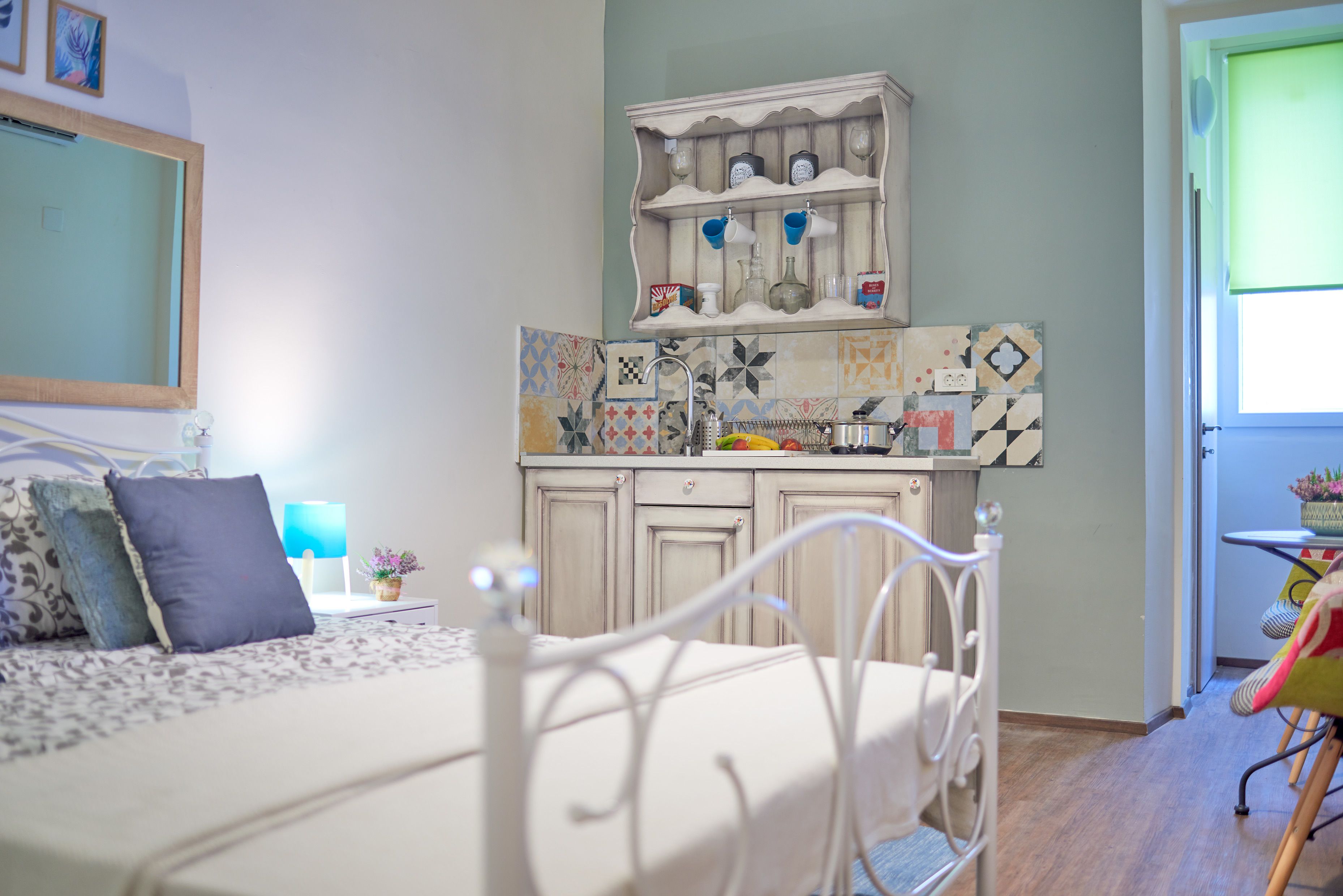 A bedroom with a bed, a nightstand, a dresser, and a window.