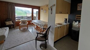 A compact living space with a balcony, a dining area, and a kitchenette. - Spacious apartment for 7 near slopes, pets allowed (Montgenèvre)
