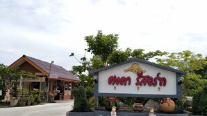 A sign with "Welcome" and a logo, surrounded by decorative elements and potted plants. - Kongka Resort (Rayong)