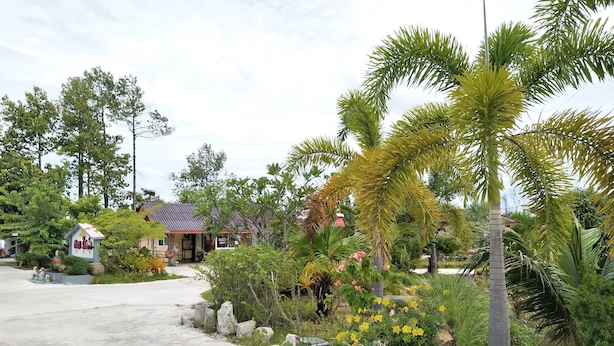 A residential area with a house, a signboard, and a well-maintained garden with various plants and flowers. - Kongka Resort (Rayong)