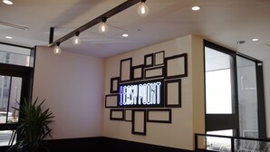 Un interior moderno con un letrero de neón que dice 'EASY POINT' y un diseño geométrico en la pared.