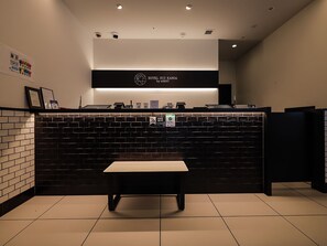 A reception area with a black counter, a bench, and a sign indicating free Wi-Fi. - HOTEL SUI KANDA byABEST (Tokyo)