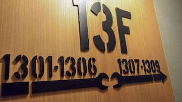 A wooden wall with room numbers and a directional arrow.