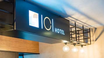 A hotel sign with a modern design, featuring a logo and the word "HOTEL" in capital letters.