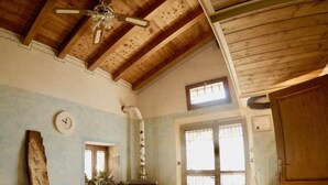 A room with a wooden ceiling, a bed, a clock, and a window. - 4lander House Balins (Clauzetto)