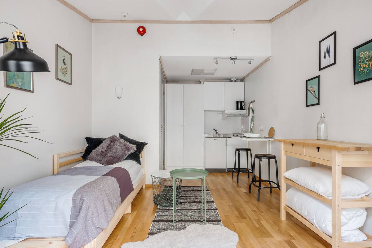Une chambre à coucher de taille réduite, comprenant un lit, une table de chevet et un petit espace bureau.