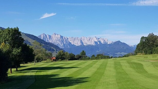 A golf course with a mountain backdrop. - Ferienwohnung Kaiserfeld (Reit im Winkl)