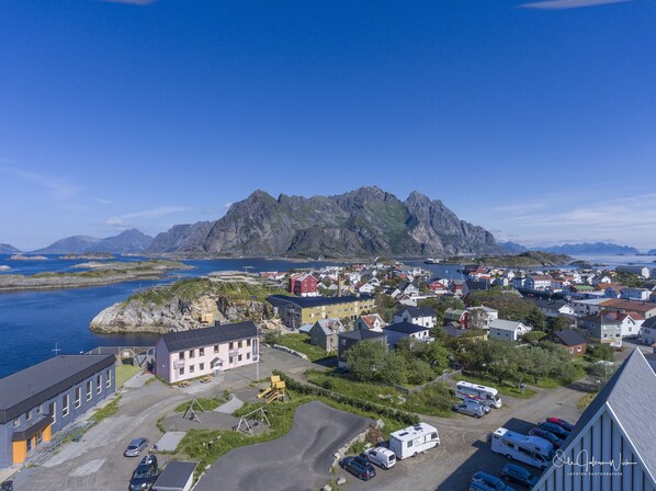 A coastal town with a prominent mountain in the background, a marina, and a variety of buildings including residential and commercial properties.