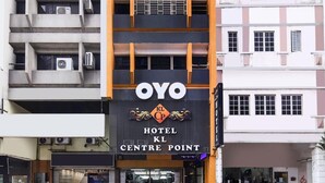 Um hotel com um letreiro 'OYO' bem visível, várias varandas e uma fachada moderna.