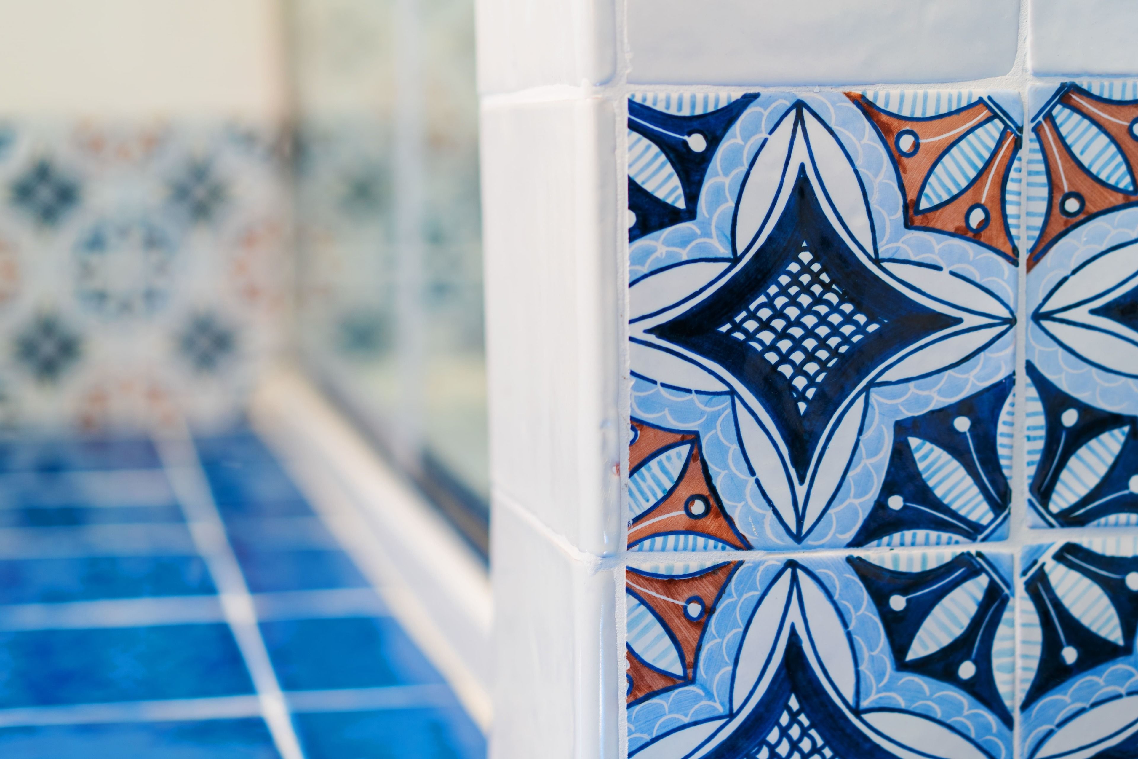 Een close-up van een betegelde muur met een geometrisch patroon.