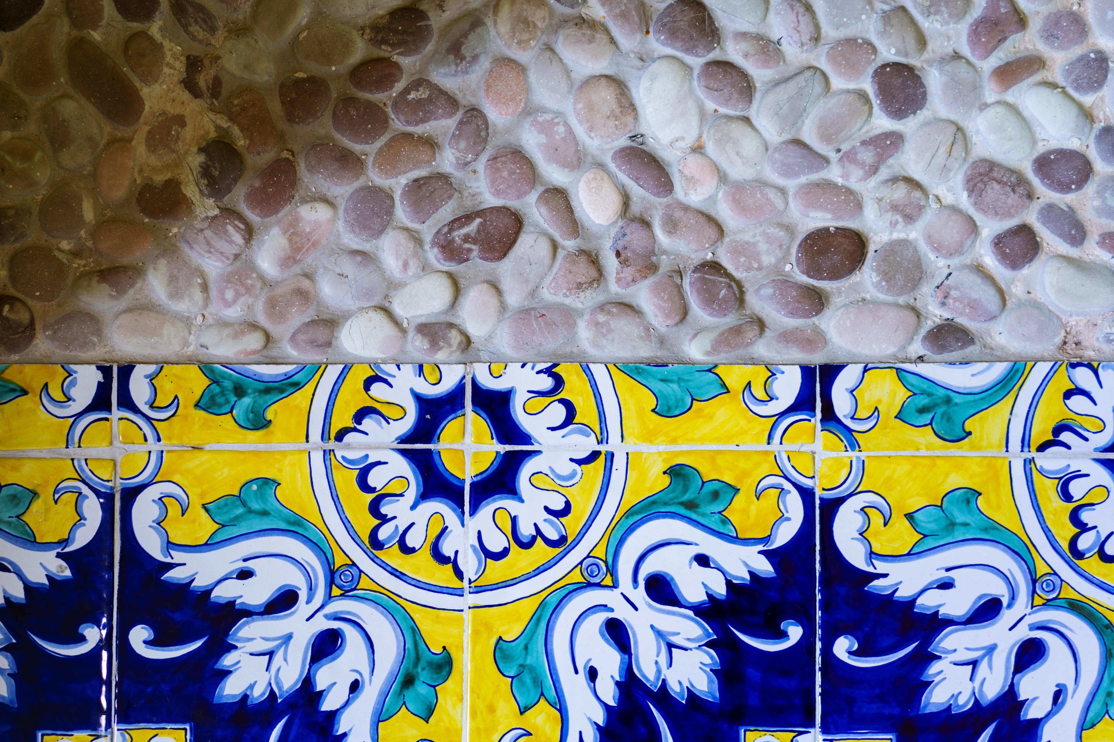 A close-up of a mosaic tile floor with a patterned tile design below.