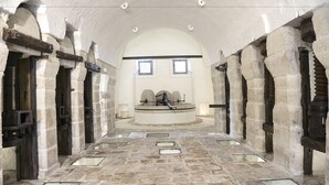 A stone corridor with arched ceilings and a central circular platform. - Masseria Capece (Cisternino)