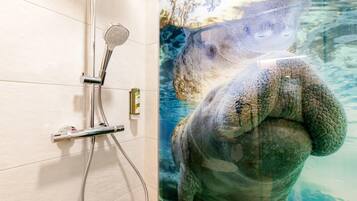 Eine Dusche mit Handbrause und Armaturen an der Wand.