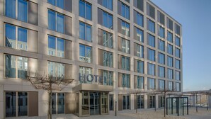 A modern hotel building with a glass facade, multiple floors, and a clear sky. - Best Western Hotel Wiesbaden (Wiesbaden)