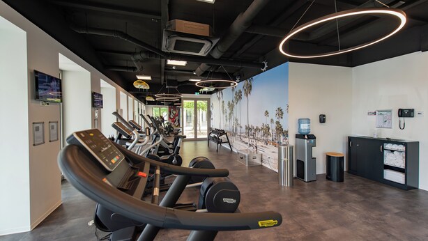 A gym with treadmills, stationary bikes, and a water dispenser. - Best Western Hotel Wiesbaden (Wiesbaden)