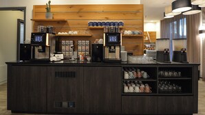 A coffee station with two espresso machines, a variety of coffee cups, and a selection of mugs and glasses. - Best Western Hotel Wiesbaden (Wiesbaden)