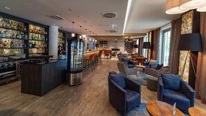 Una zona de bar con estantes llenos de botellas, una barra y asientos con mesas y sillas.