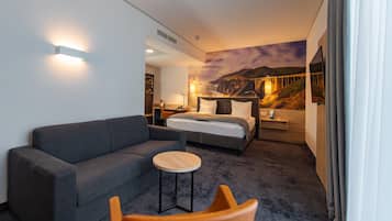 Ein Hotelzimmer mit einem Bett, einer Couch, einem kleinen Tisch und einem Sessel.