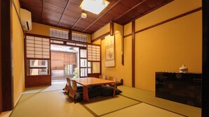 Una habitación tradicional japonesa con suelo de tatami, una mesa de madera y una puerta corredera.