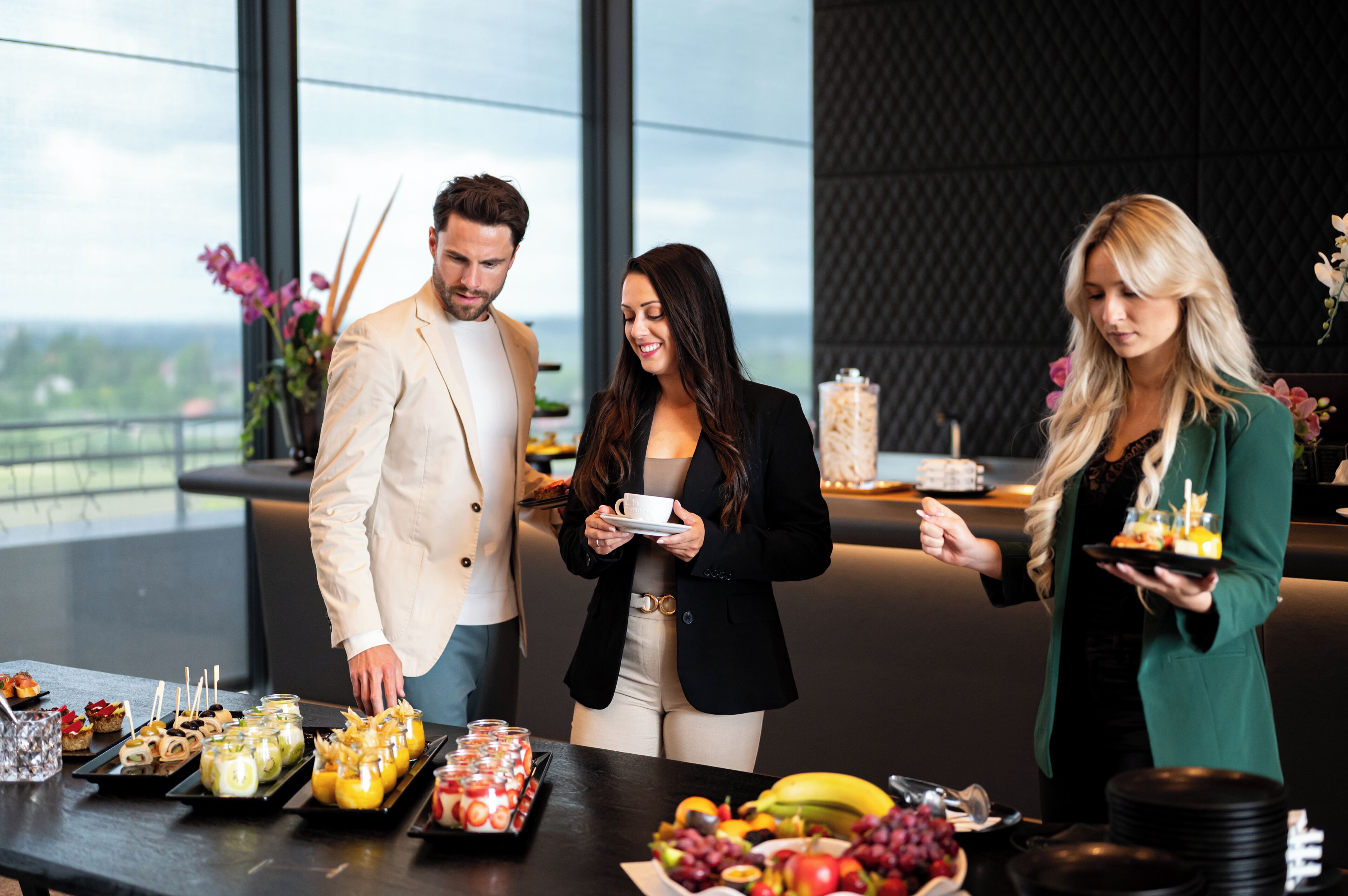 A buffet with various food items and a city view in the background.