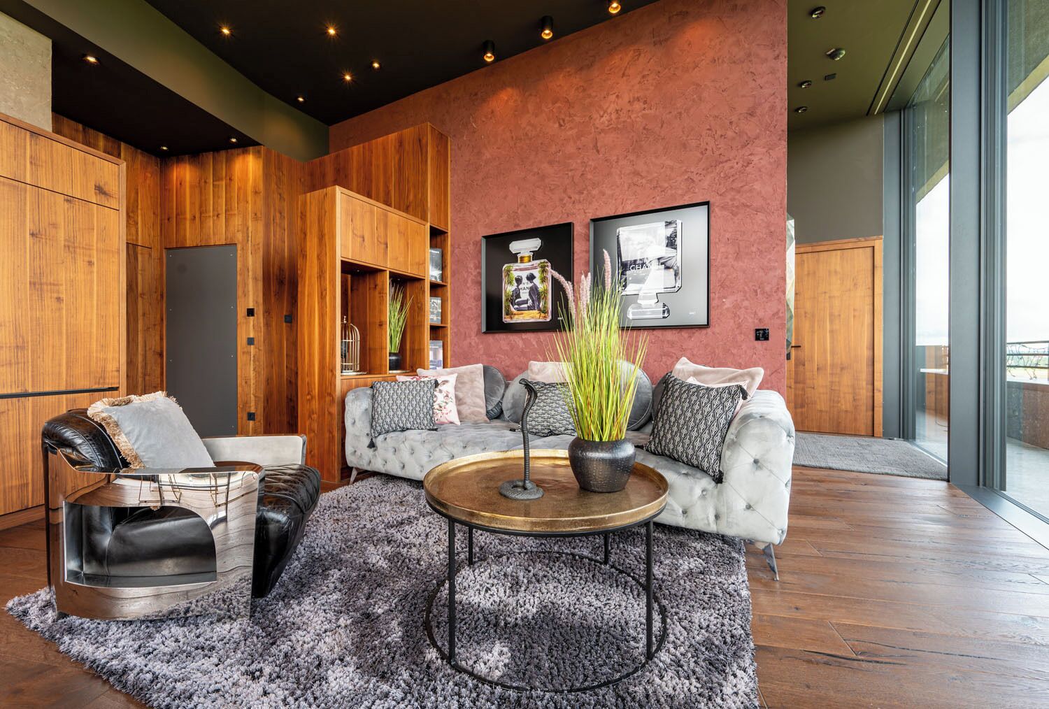 A modern living room with a sofa, armchairs, a coffee table, and a large window.