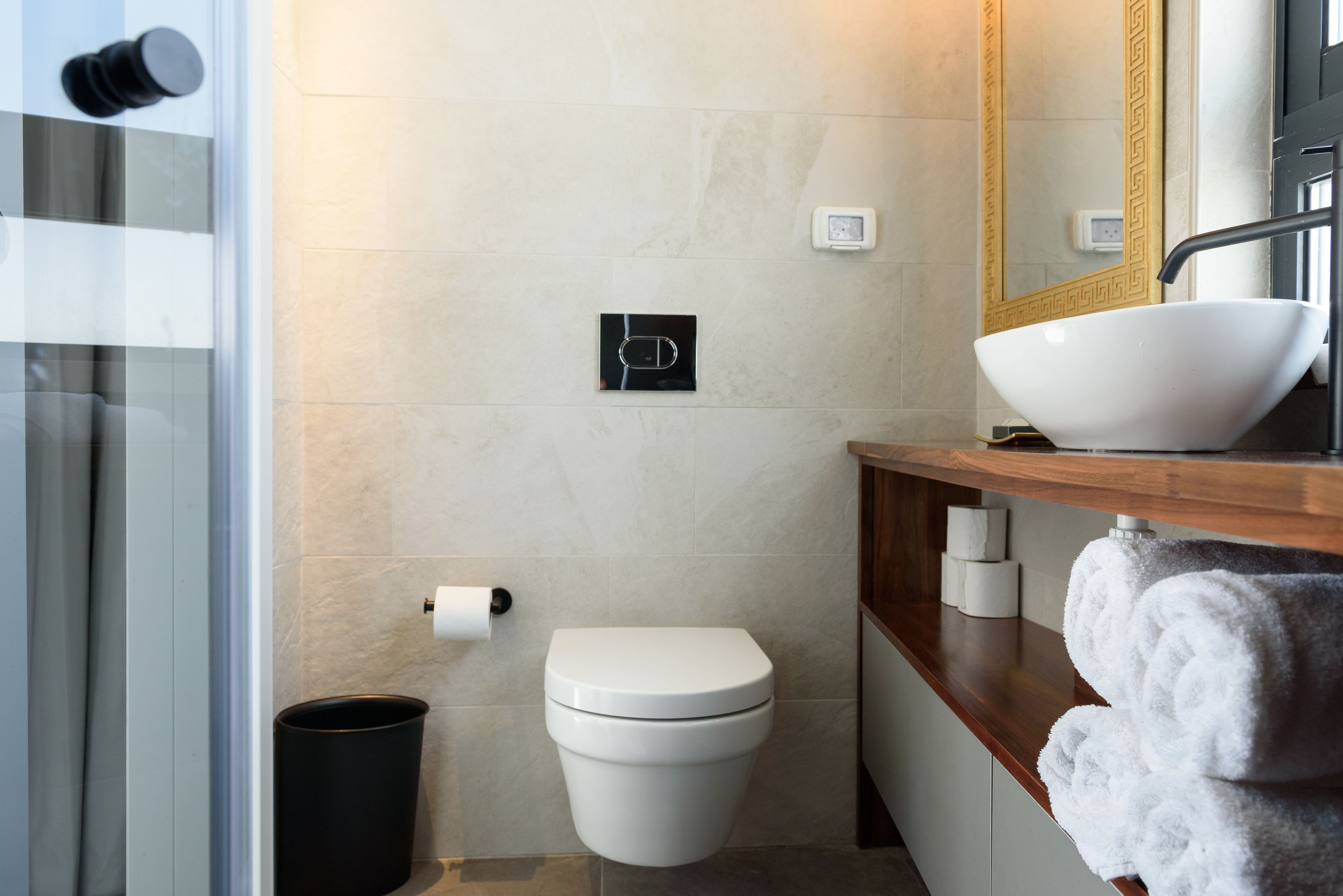 A modern bathroom with a toilet, bidet, and a large sink with a bowl.