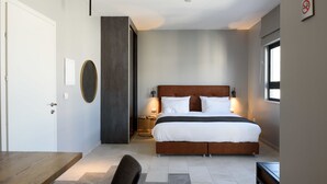 Une chambre moderne avec un grand lit, des tables de chevet, un bureau et une chaise.