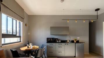 A modern kitchen with a dining area, large windows, and a view of the city.