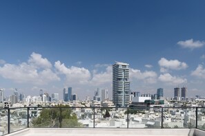 Stadsbeeld met moderne wolkenkrabbers, een heldere lucht en een balkon met uitzicht op de stad.