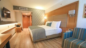 Une chambre d’hôtel avec un lit, un canapé, un bureau et une télévision.