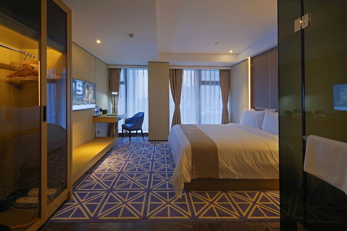 Een hotelkamer met een bed, een bureau, een stoel en een kledingkast.