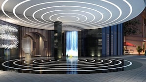 Un bâtiment moderne à la conception circulaire, doté d’un élément d’éclairage central et d’un sol réfléchissant.