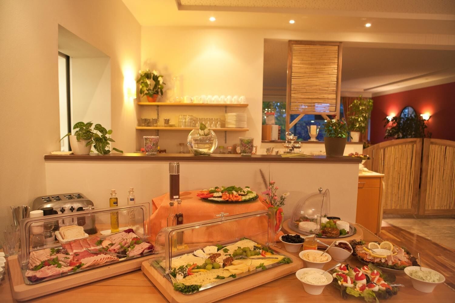 A buffet setup with various food items and a toaster.