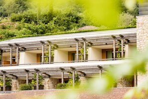 Un immeuble à plusieurs étages doté d’un balcon et de piliers en pierre.