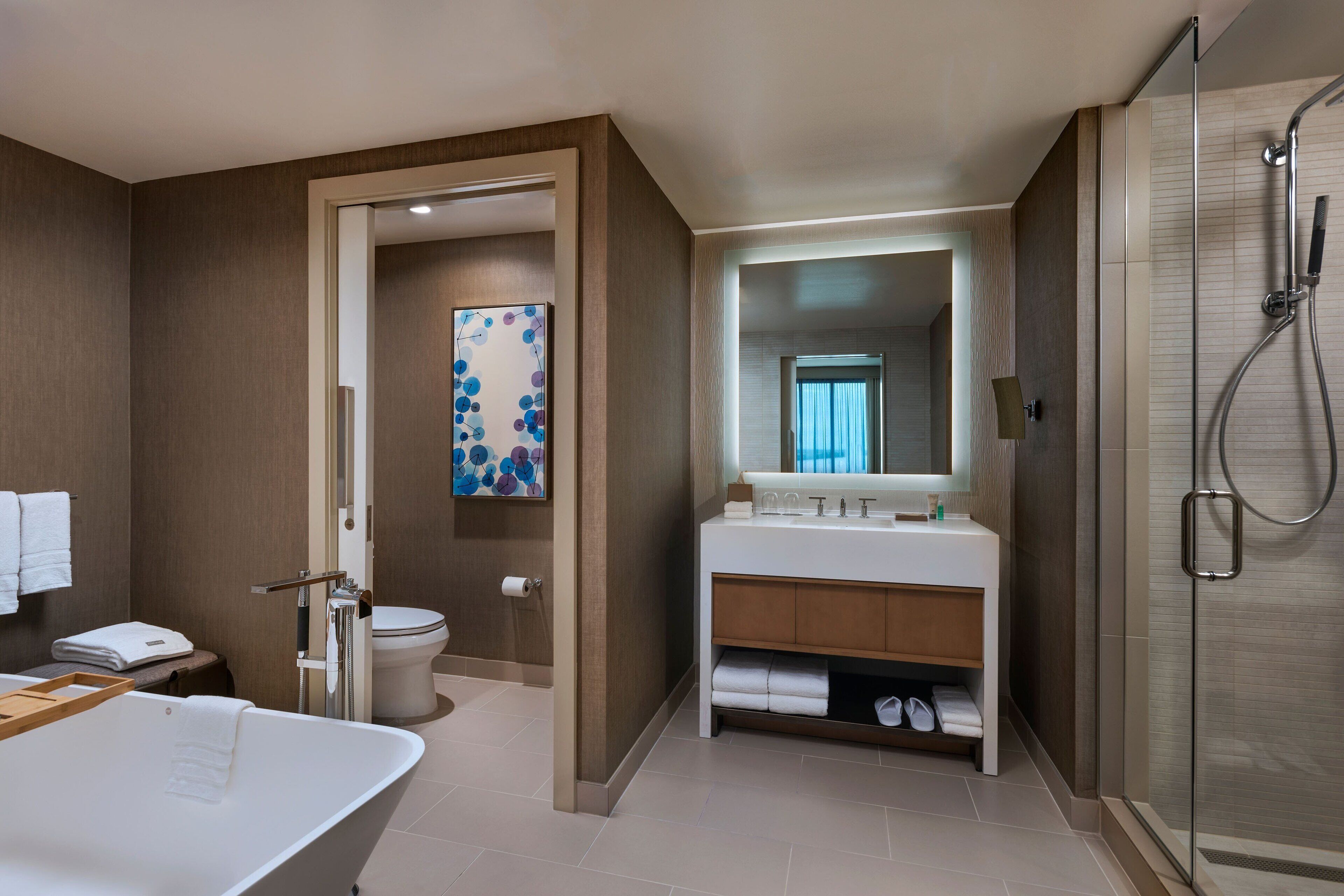 A modern bathroom with a freestanding bathtub, a shower enclosure, and a vanity with a mirror.