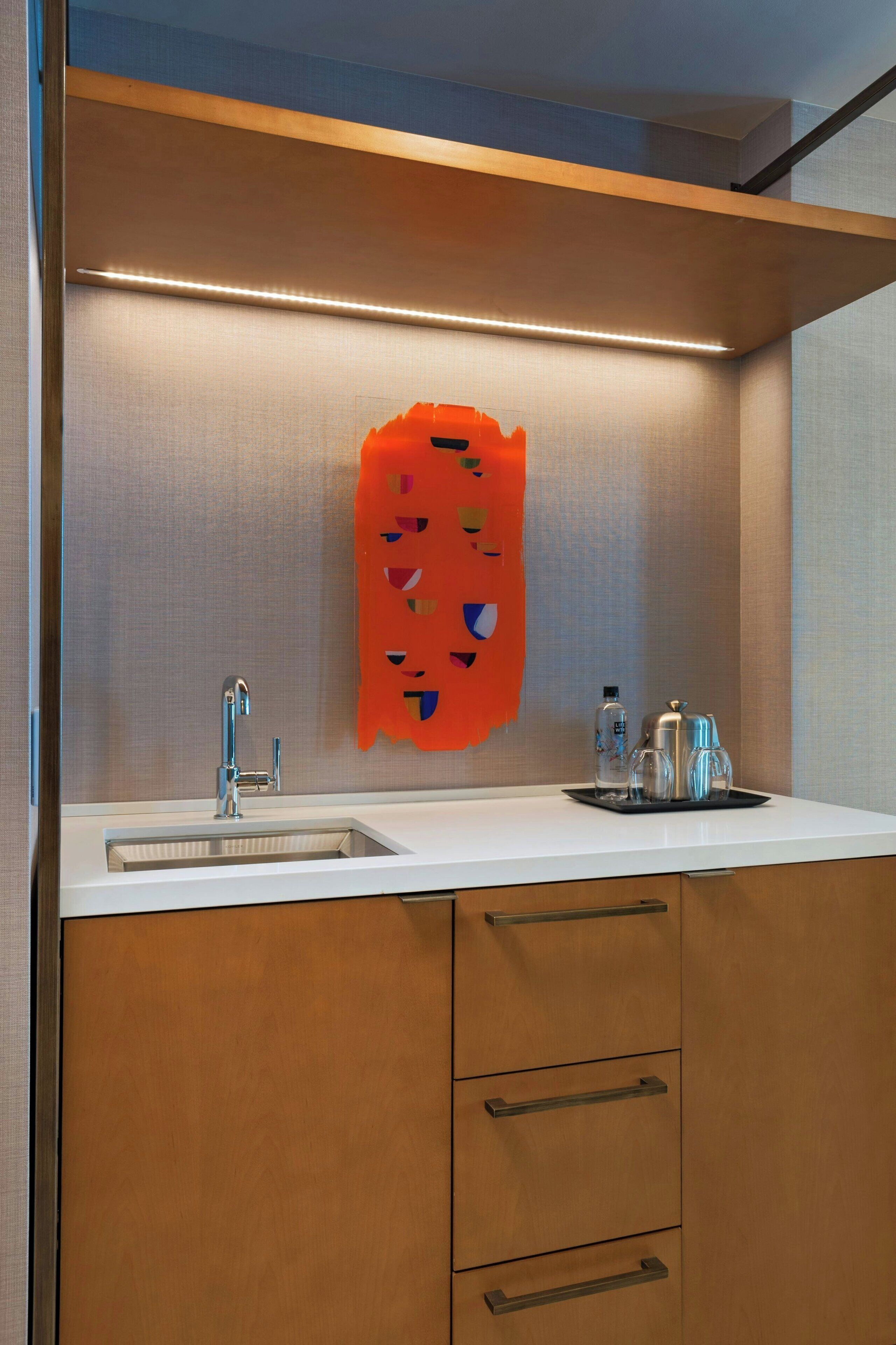 Un baño moderno con lavamanos, espejo y armarios de almacenamiento.