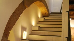 A staircase with a stone archway and a handrail.