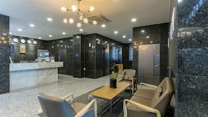 A modern lobby with a reception desk, seating area, and a large chandelier. - Gimpo Pentastar Hotel (Gimpo)