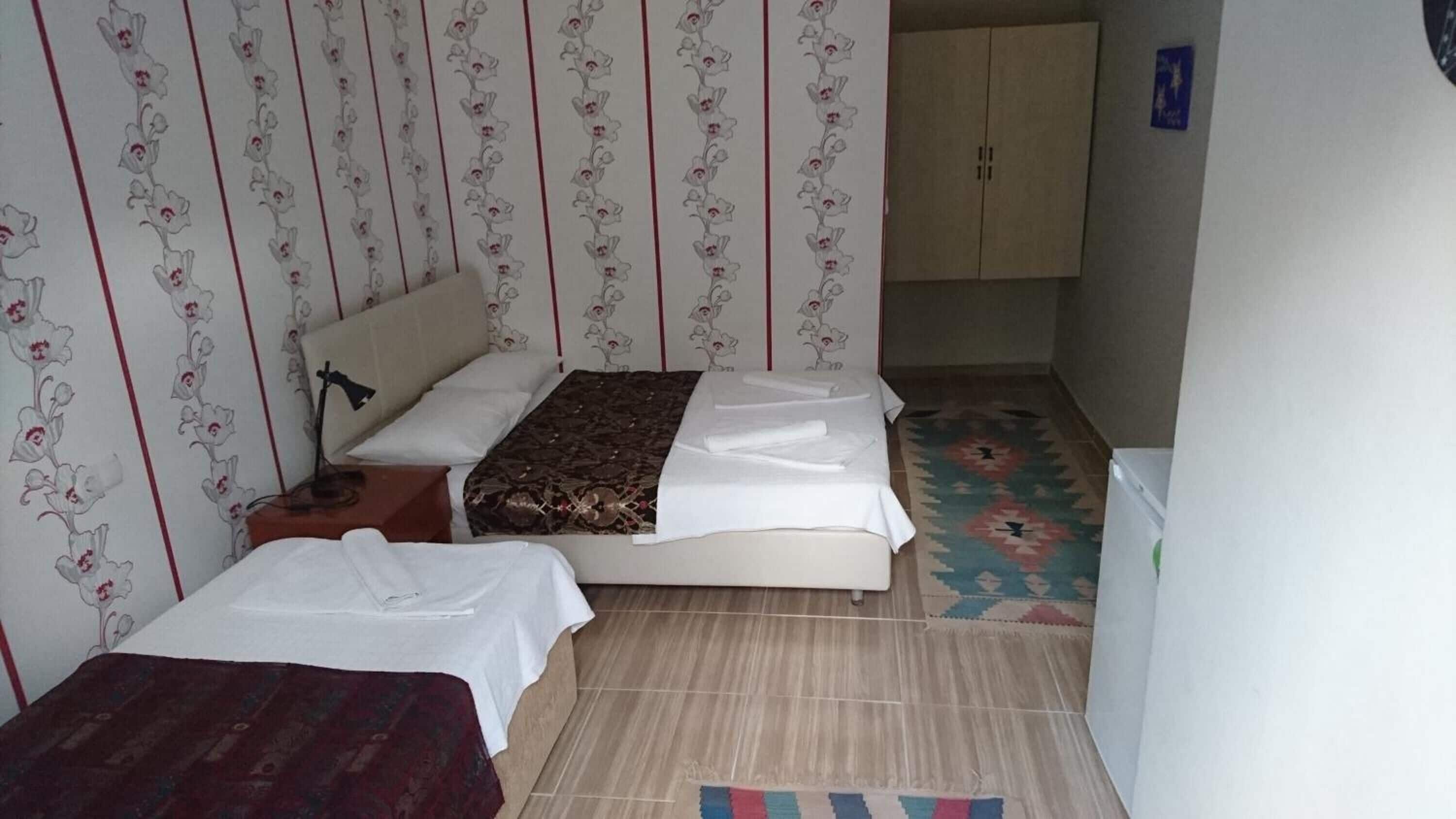 A small, neatly arranged bedroom with a bed, a bedside table, and a wardrobe.
