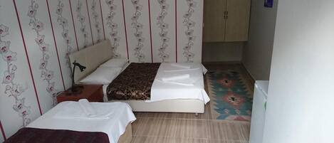 A small, neatly arranged bedroom with a bed, a bedside table, and a wardrobe.