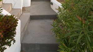 Une maison en pierre avec un escalier en pierre menant à une porte en bois.