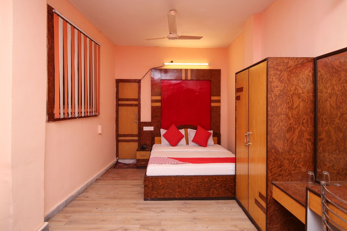 A bedroom with a bed, wardrobe, and a ceiling fan.