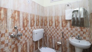 Un baño con inodoro, lavamanos y ducha.