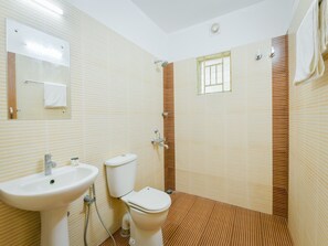 Un baño con lavamanos, inodoro y ducha.