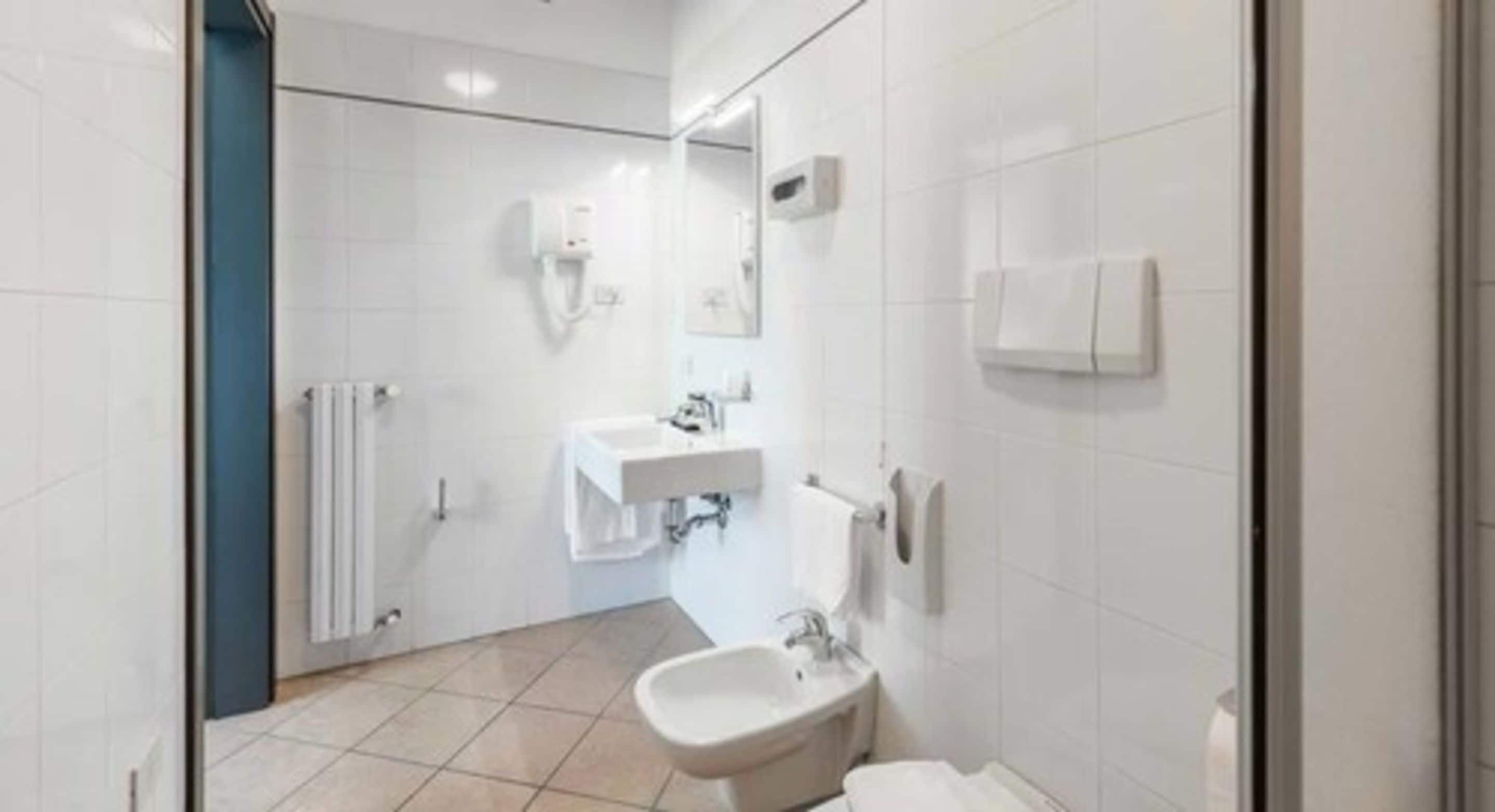 Un baño moderno con bidé, lavabo y espejo.