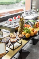 A buffet with various food items including pastries, fruits, and beverages.