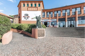 Stunning public square with a historic building featuring a crest and statue of two figures.