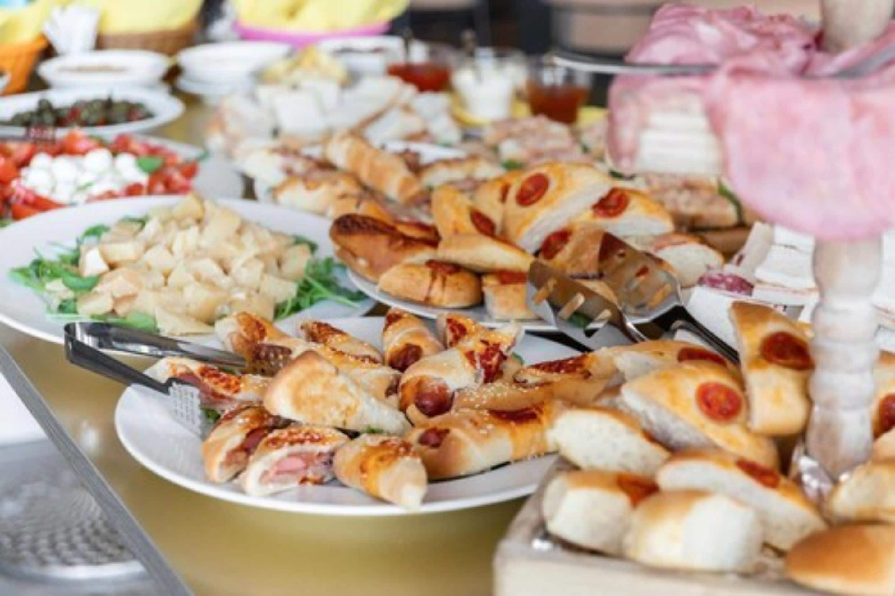 A buffet with various dishes including salads, meats, and pastries.