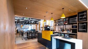 A modern bar area with a wooden ceiling, yellow pendant lights, and a counter with a black and white color scheme. - Staycity Aparthotels, Liverpool, Waterfront (Liverpool)