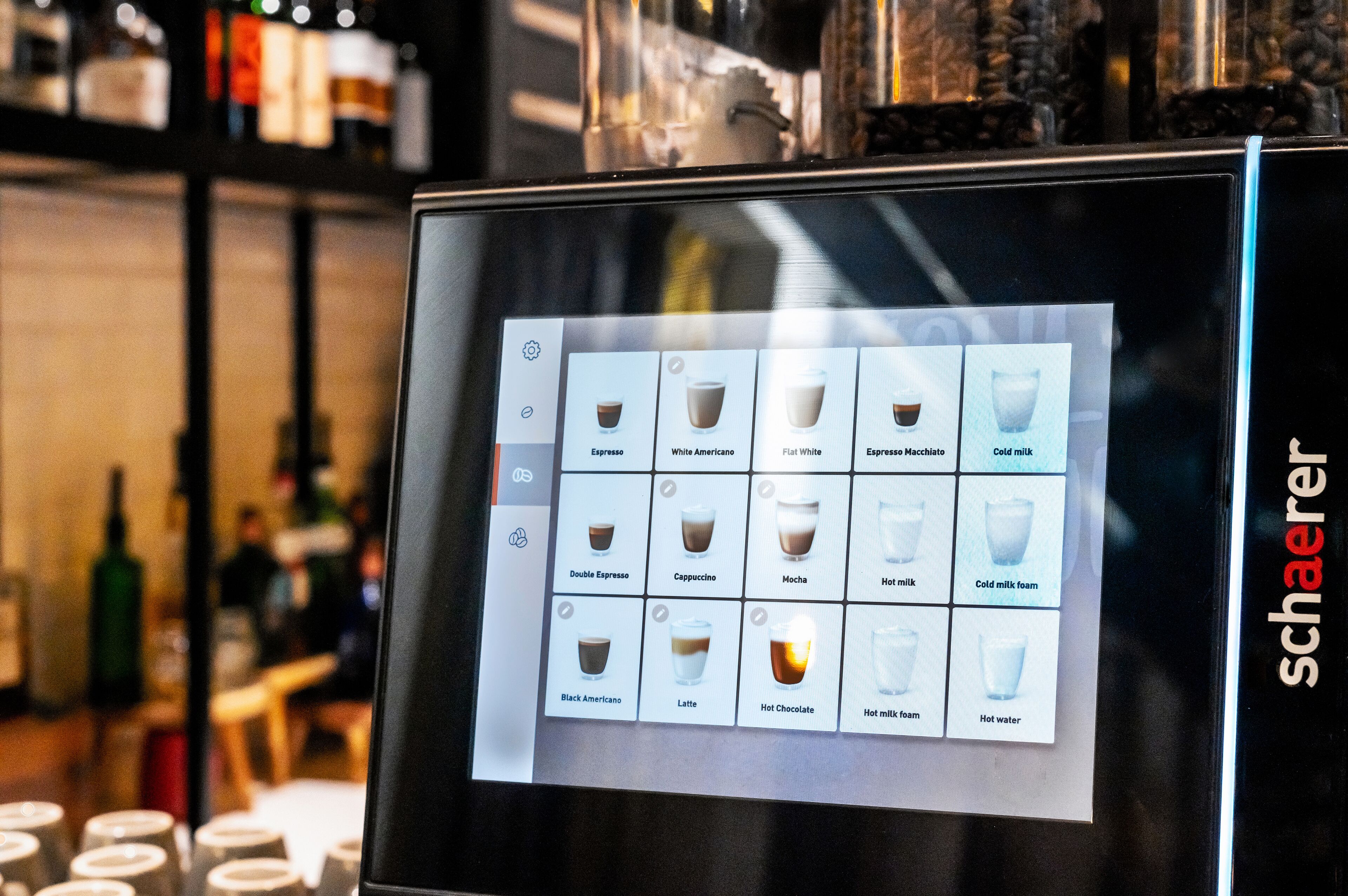 A digital menu display with various coffee and drink options.
